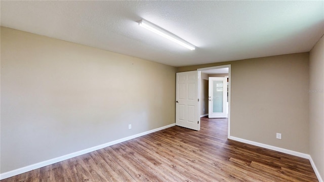 unfurnished room featuring a textured ceiling and wood-type flooring