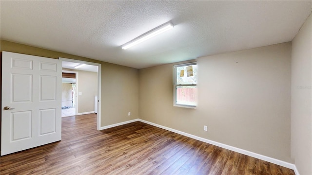 empty room with a textured ceiling and hardwood / wood-style floors