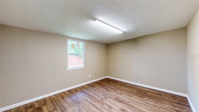 unfurnished room with hardwood / wood-style floors and a textured ceiling