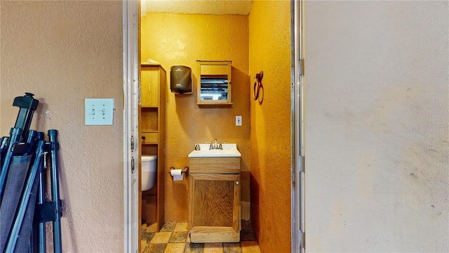 bathroom with toilet, tile patterned flooring, and vanity