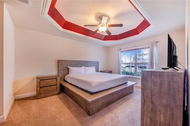 bedroom featuring a tray ceiling, ceiling fan, and light colored carpet