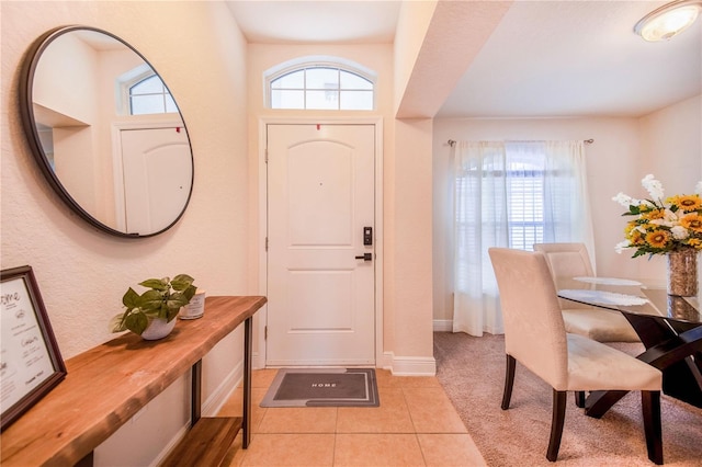 foyer entrance with light tile patterned flooring and baseboards