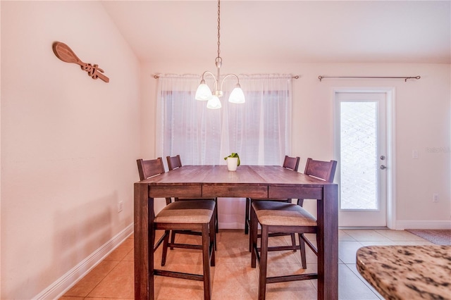 dining space with lofted ceiling, a notable chandelier, light tile patterned flooring, and baseboards