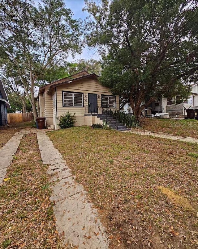 bungalow-style home with a front yard