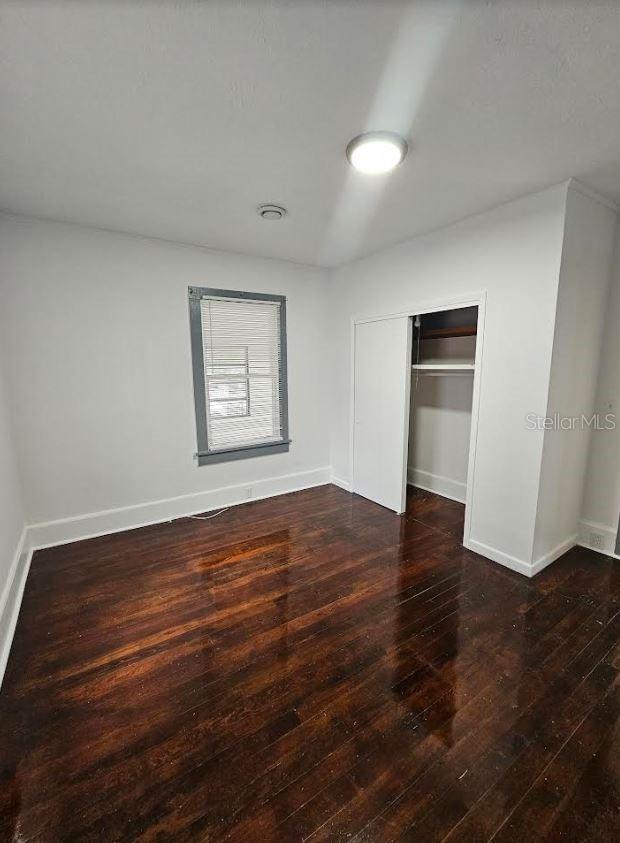 1414 Johns Ave, Haines City, FL 33844 - unfurnished bedroom with dark hardwood / wood-style flooring and a closet