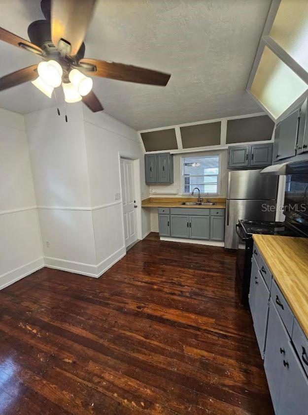 1414 Johns Ave, Haines City, FL 33844 - kitchen with ceiling fan, gray cabinetry, dark wood-type flooring, and wooden counters