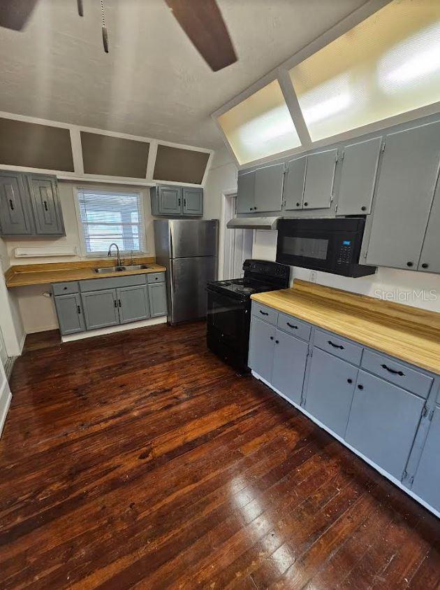 1414 Johns Ave, Haines City, FL 33844 - kitchen featuring butcher block countertops, sink, dark wood-type flooring, and black appliances