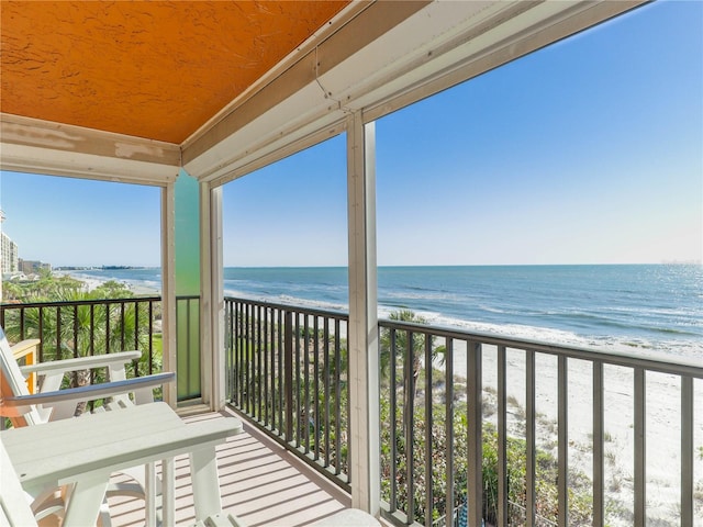 balcony with a water view and a beach view