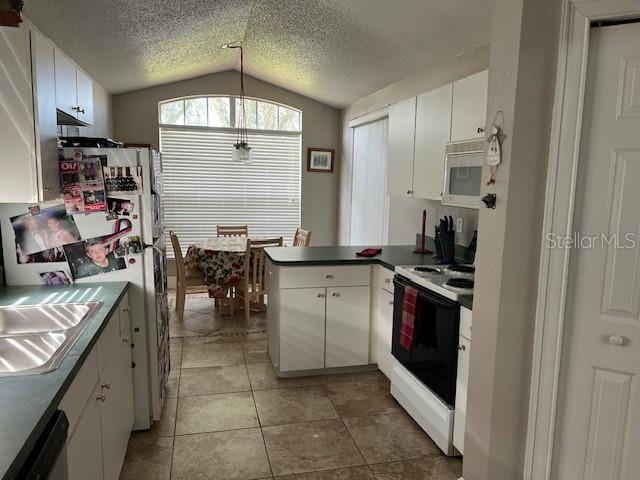 kitchen with white appliances, light tile patterned floors, a peninsula, vaulted ceiling, and white cabinets