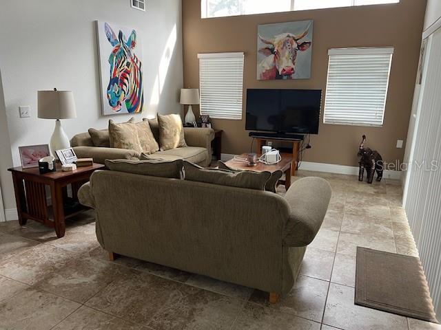 tiled living room featuring a high ceiling