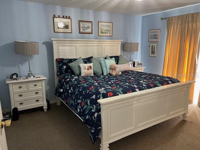 carpeted bedroom with a textured ceiling