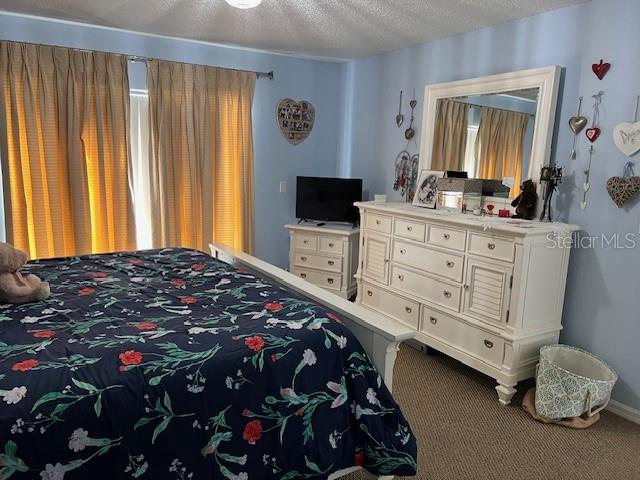 carpeted bedroom featuring a textured ceiling