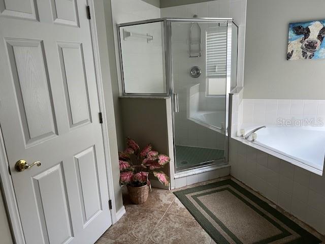 bathroom featuring plus walk in shower and tile patterned flooring