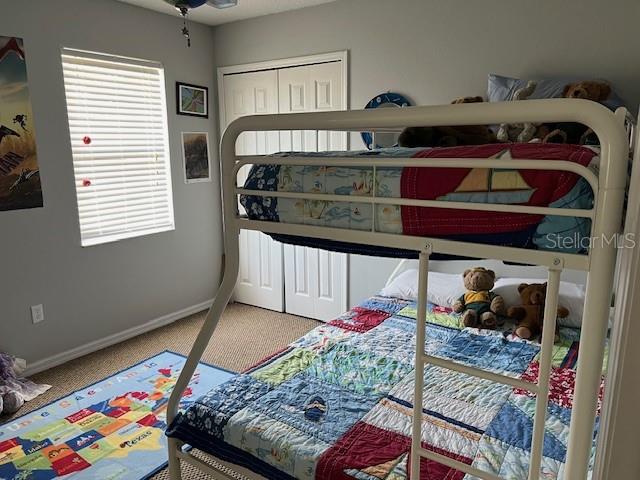 carpeted bedroom with multiple windows and a closet