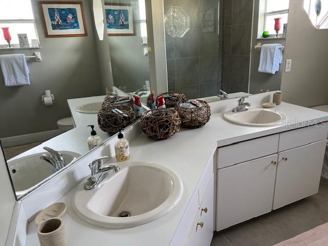 full bath featuring double vanity, toilet, and a sink