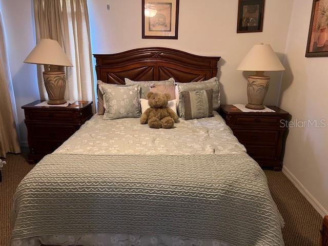 carpeted bedroom featuring baseboards