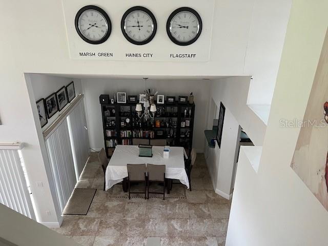 dining area featuring light tile patterned flooring and an inviting chandelier