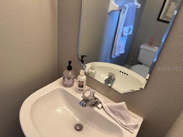 bathroom with a textured wall and a sink