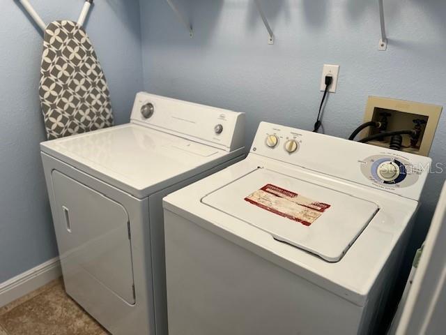 laundry room featuring washer and dryer and light tile patterned floors