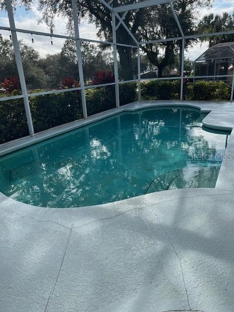 pool featuring a lanai and a patio area