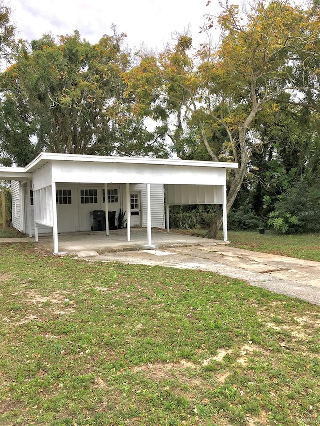 exterior space featuring a front lawn and a carport