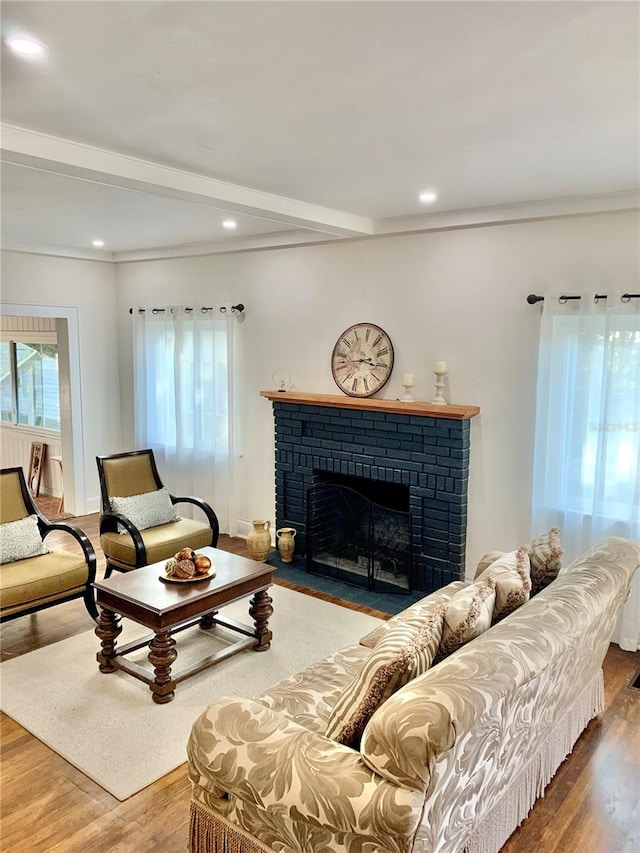 living room featuring a fireplace, crown molding, and hardwood / wood-style flooring