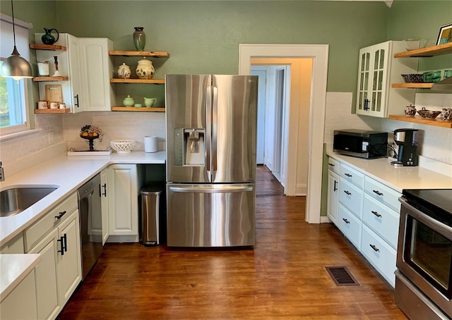 kitchen with white cabinets, hanging light fixtures, sink, stainless steel appliances, and dark hardwood / wood-style flooring