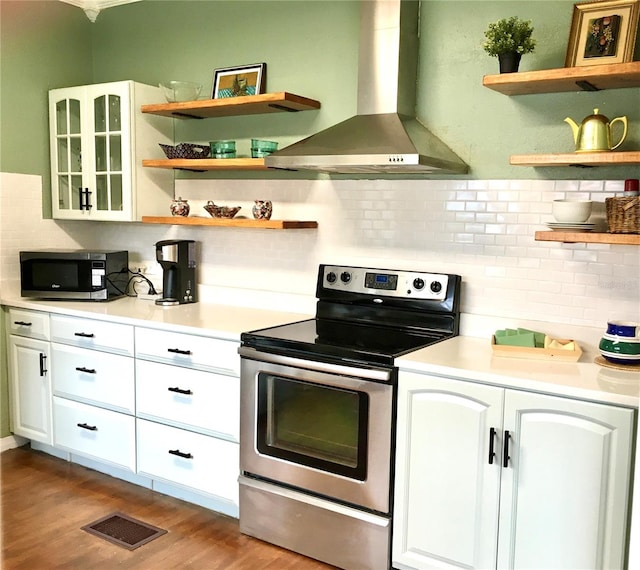 kitchen featuring white cabinets, island range hood, light hardwood / wood-style flooring, stainless steel appliances, and decorative backsplash