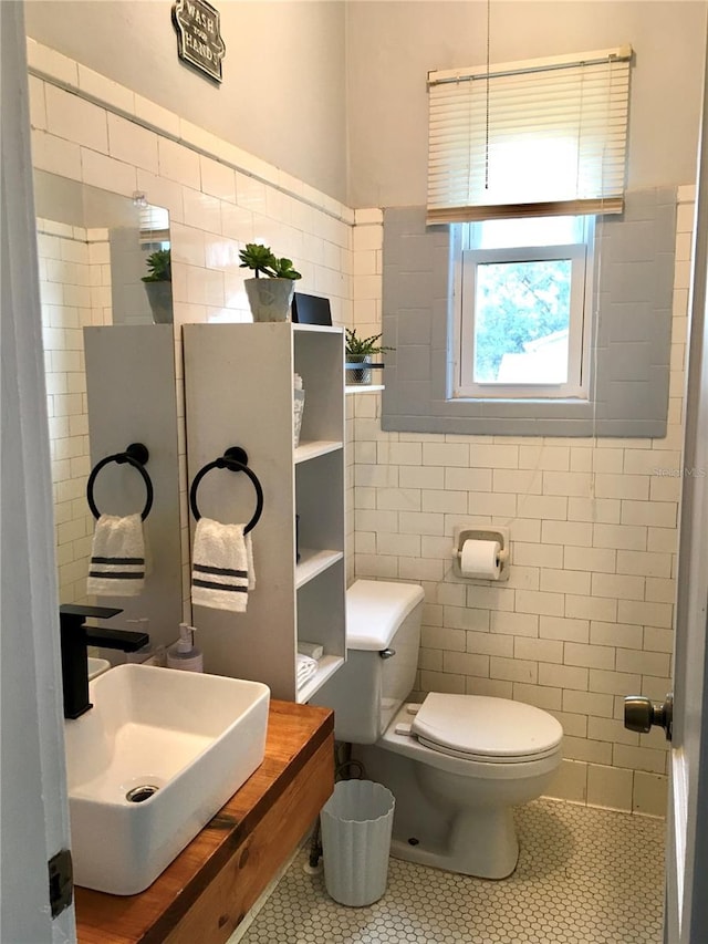 bathroom featuring tile walls, tile patterned floors, sink, and toilet