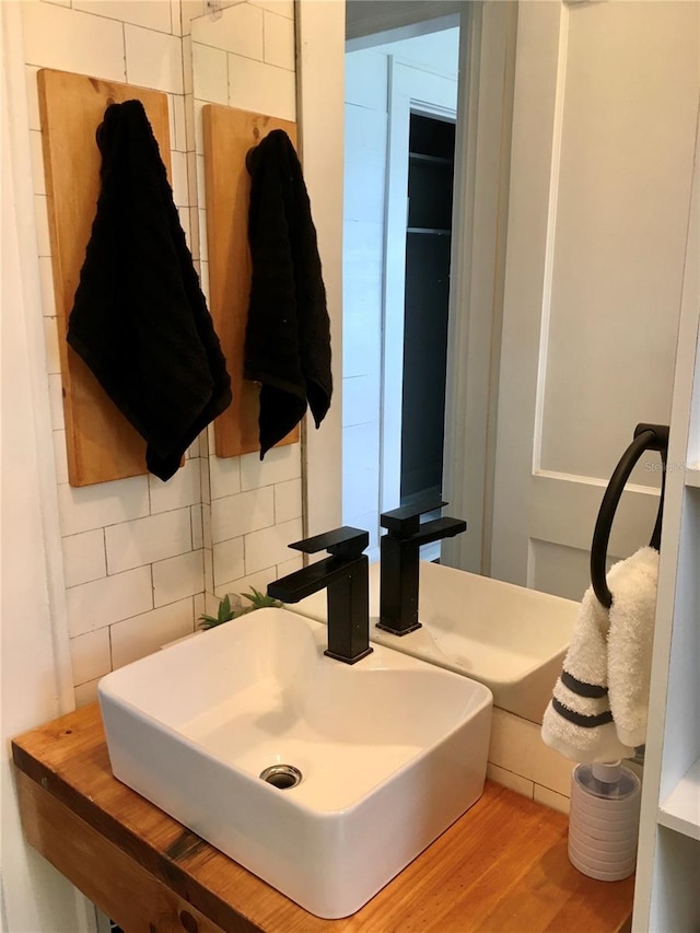 bathroom featuring decorative backsplash, wood-type flooring, sink, and tile walls