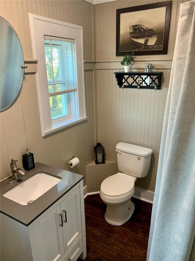 bathroom with hardwood / wood-style flooring, toilet, and vanity