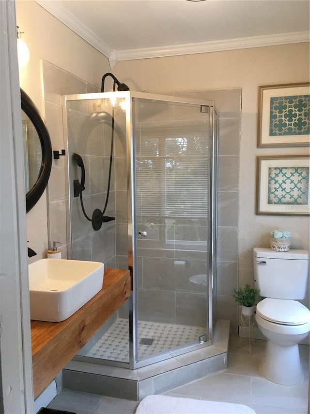 bathroom featuring vanity, toilet, an enclosed shower, crown molding, and tile patterned flooring