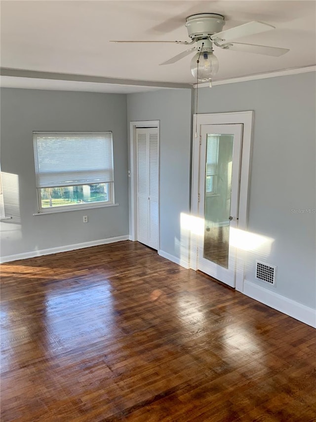 unfurnished room with ceiling fan, ornamental molding, and dark hardwood / wood-style flooring