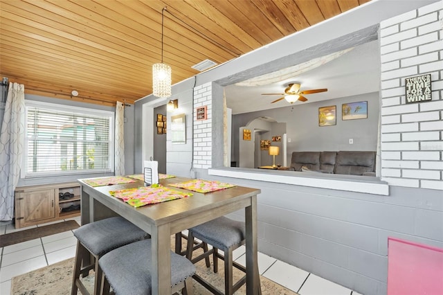 tiled dining room featuring wood ceiling and ceiling fan