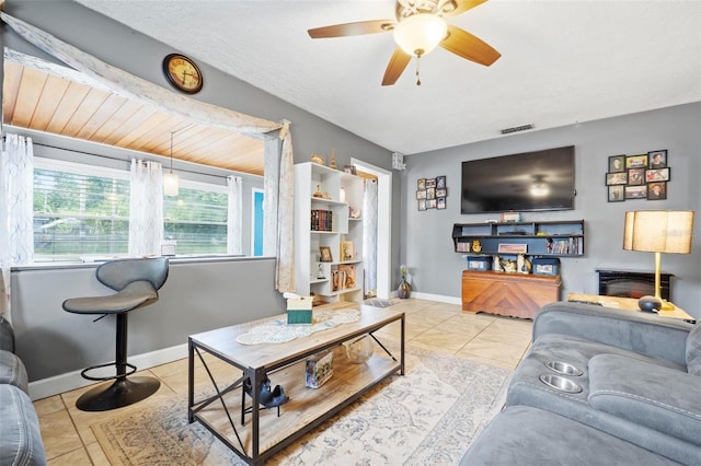 living room with ceiling fan, tile floors, and a textured ceiling