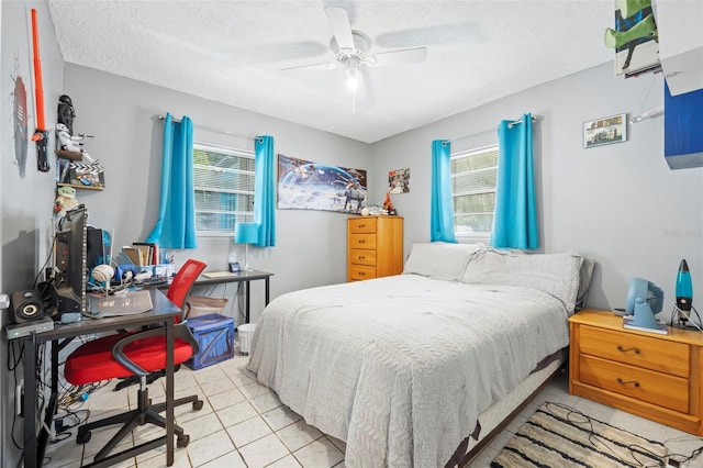 bedroom with a textured ceiling, ceiling fan, and tile floors