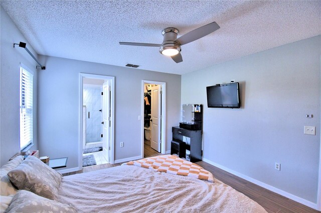 bedroom featuring ceiling fan, a spacious closet, connected bathroom, and multiple windows