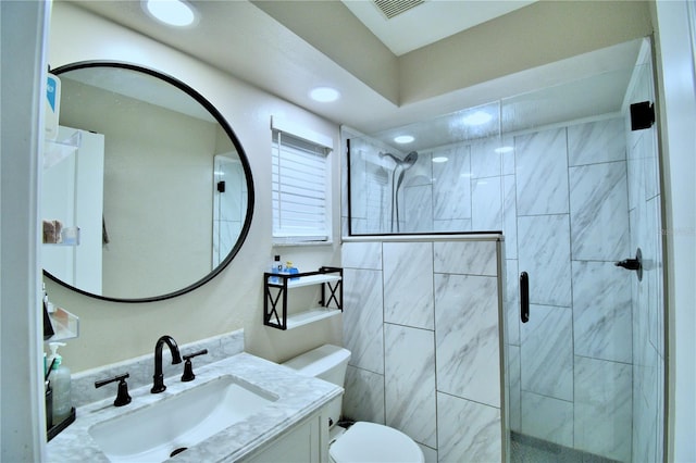 bathroom featuring walk in shower, toilet, and vanity
