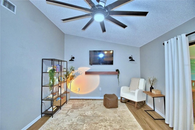 sitting room with a textured ceiling, ceiling fan, and light wood-type flooring