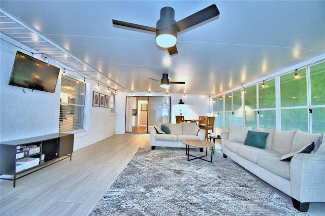 living room with ceiling fan and light wood-type flooring