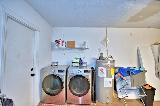 laundry area featuring a textured ceiling, washing machine and dryer, and water heater