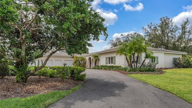 2300 N Scenic Hwy Unit 111, Lake Wales, FL 33898 - view of front of house featuring asphalt driveway, stucco siding, a front lawn, and a garage