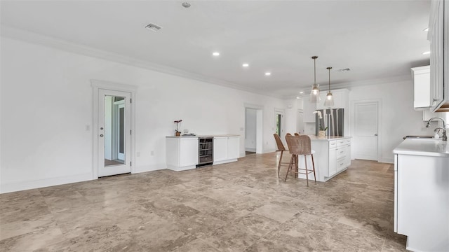 2300 N Scenic Hwy Unit 111, Lake Wales, FL 33898 - kitchen with crown molding, freestanding refrigerator, a kitchen breakfast bar, white cabinetry, and light countertops