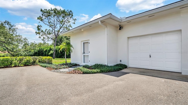 2300 N Scenic Hwy Unit 111, Lake Wales, FL 33898 - view of side of property featuring stucco siding, asphalt driveway, and an attached garage