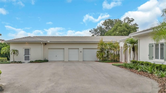 2300 N Scenic Hwy Unit 111, Lake Wales, FL 33898 - view of front of home with driveway, an attached garage, a tile roof, and stucco siding