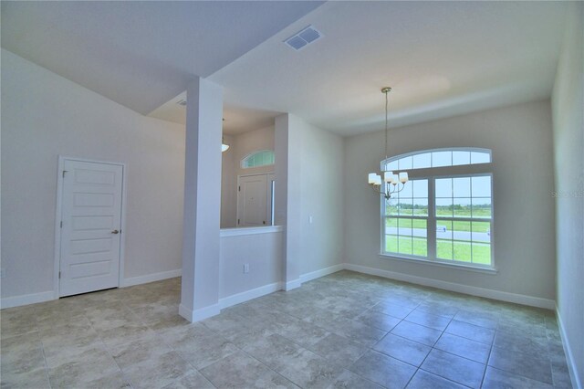 spare room featuring an inviting chandelier