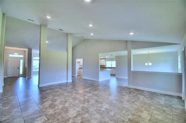 unfurnished room with high vaulted ceiling