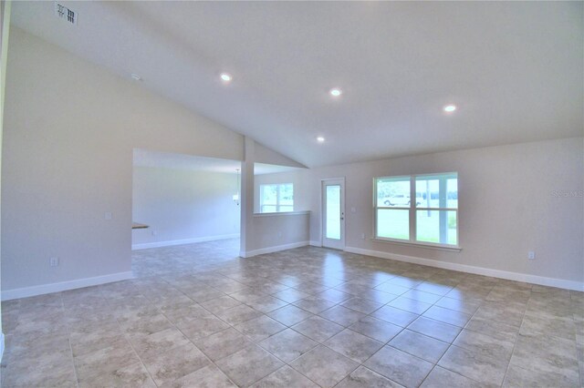 tiled empty room featuring lofted ceiling