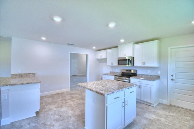 kitchen with light stone countertops, white cabinets, and stainless steel appliances