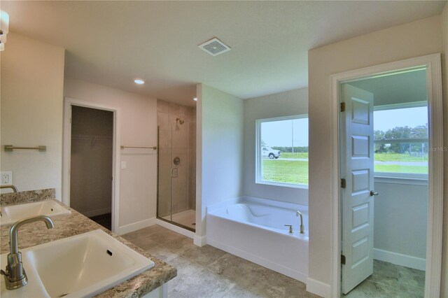 bathroom with vanity and shower with separate bathtub